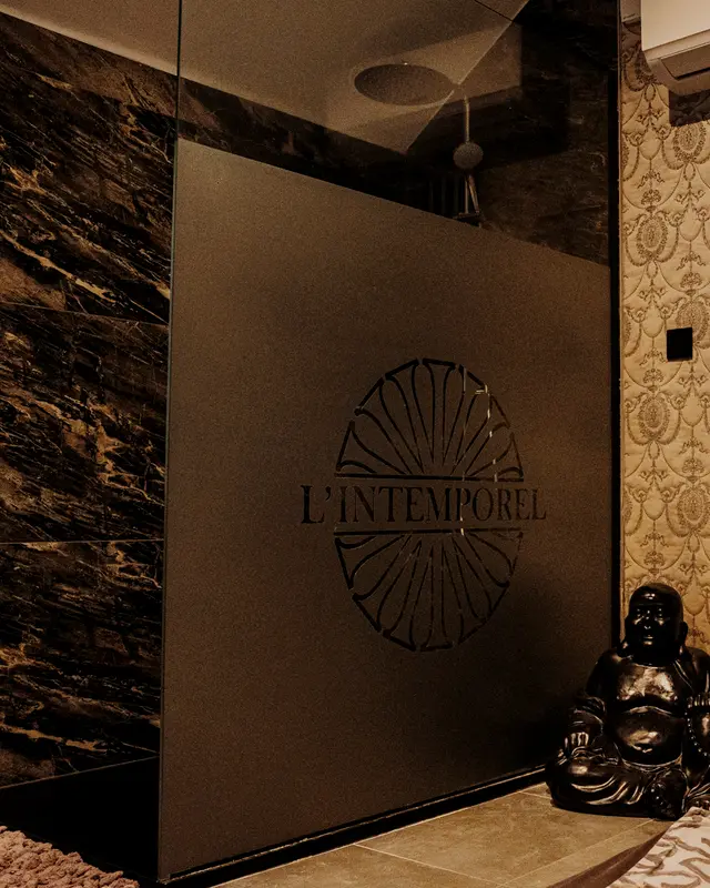 Douche à l’italienne : paroi de verre gravée du logo, marbre sombre
